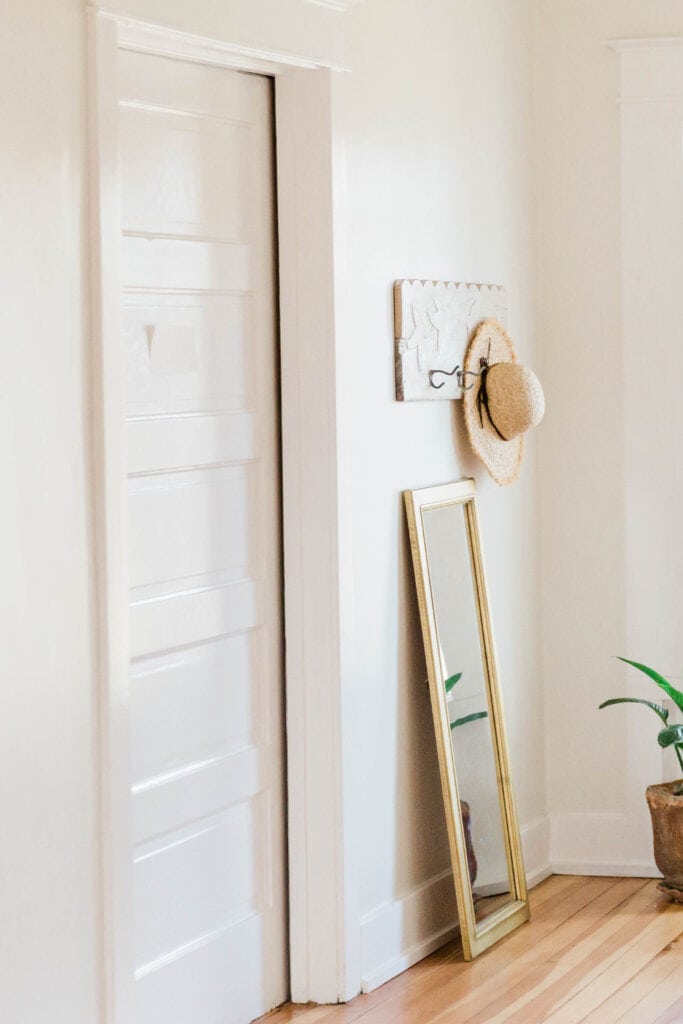 white paneled door in a room with white walls and wood flooring