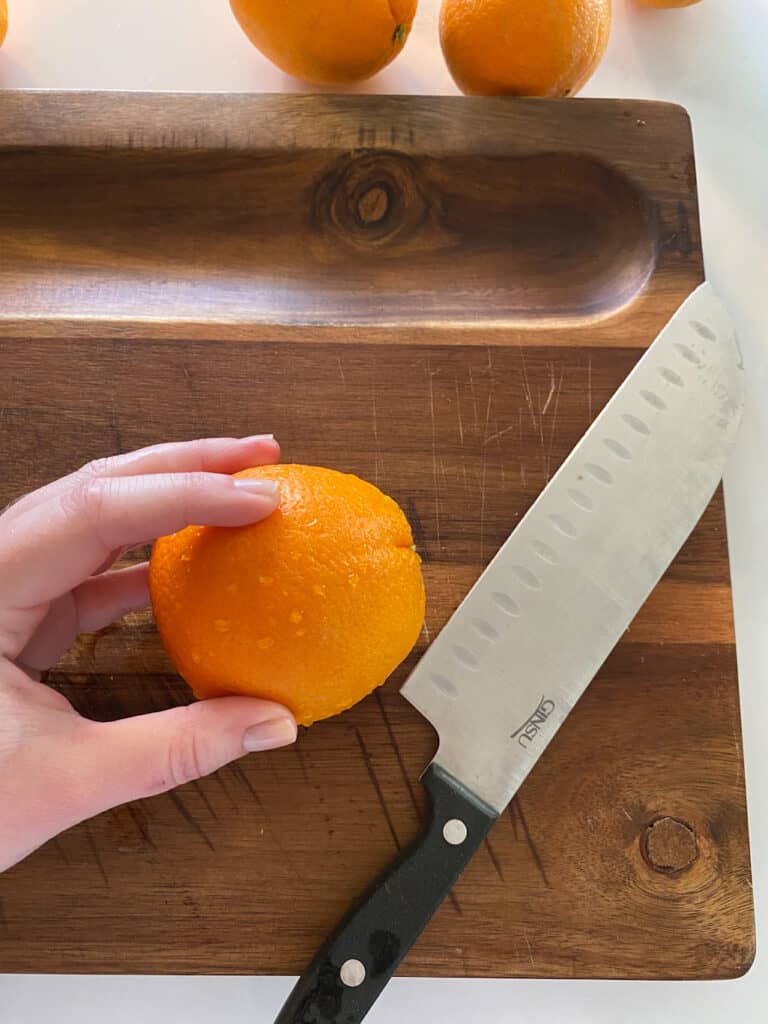 orange on cutting board with sharp knife