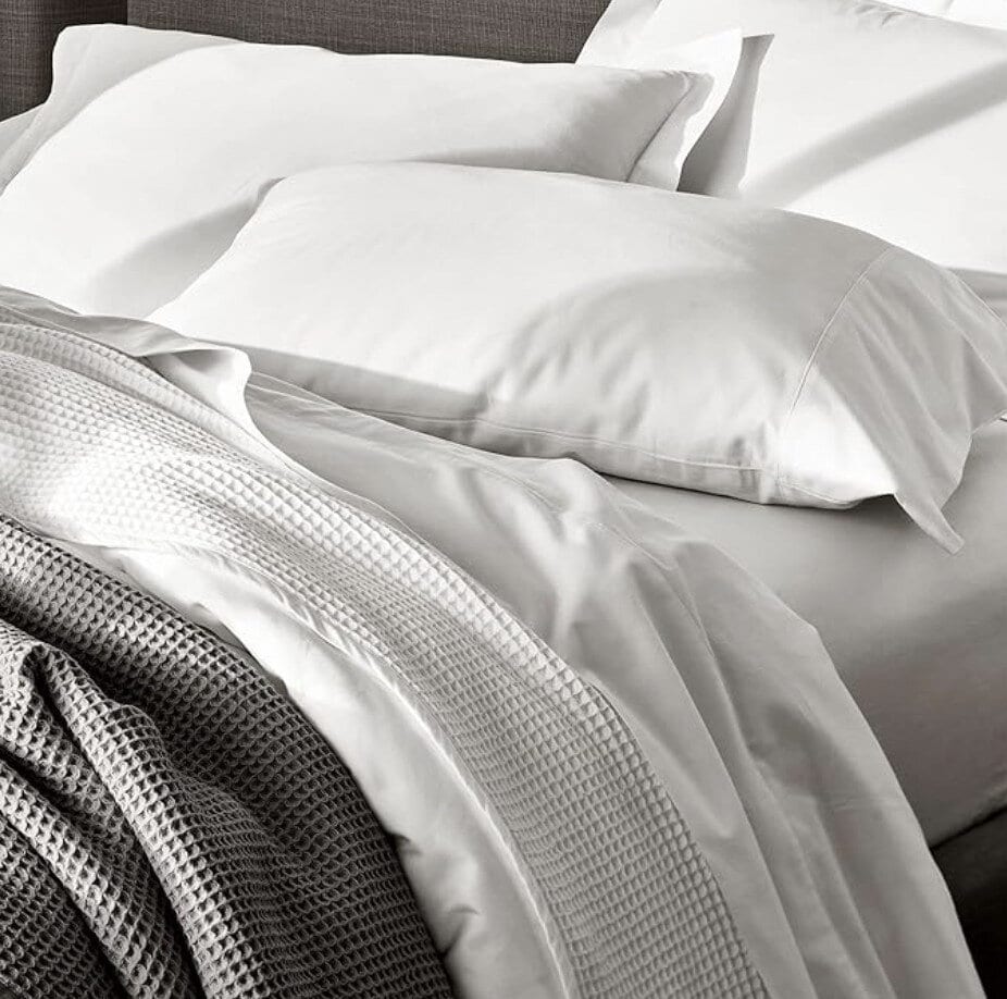 white sheets on bed with waffle blankets