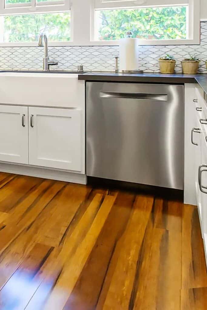 White kitchen cabinets with bamboo flooring.