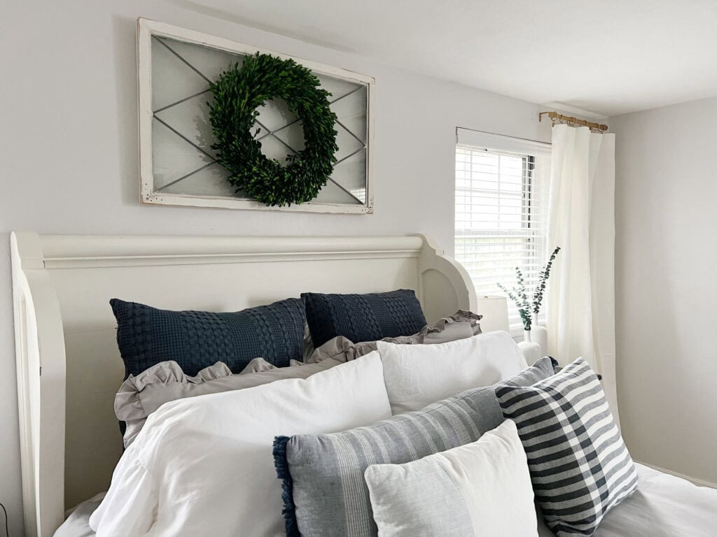 Throw pillows on blue, gray, and white themed layered bedding