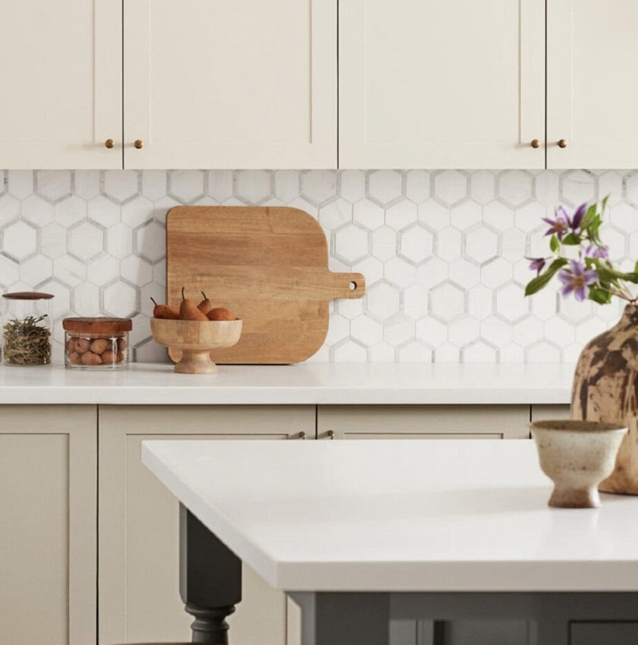 Cream colored kitchen cabinets with marble backsplash