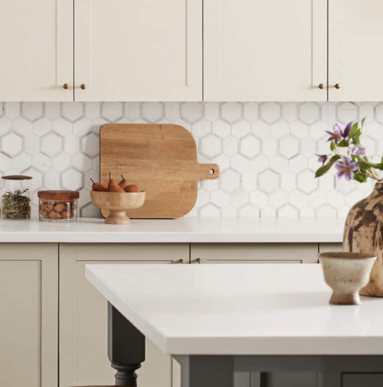 Cream colored kitchen cabinets with marble backsplash